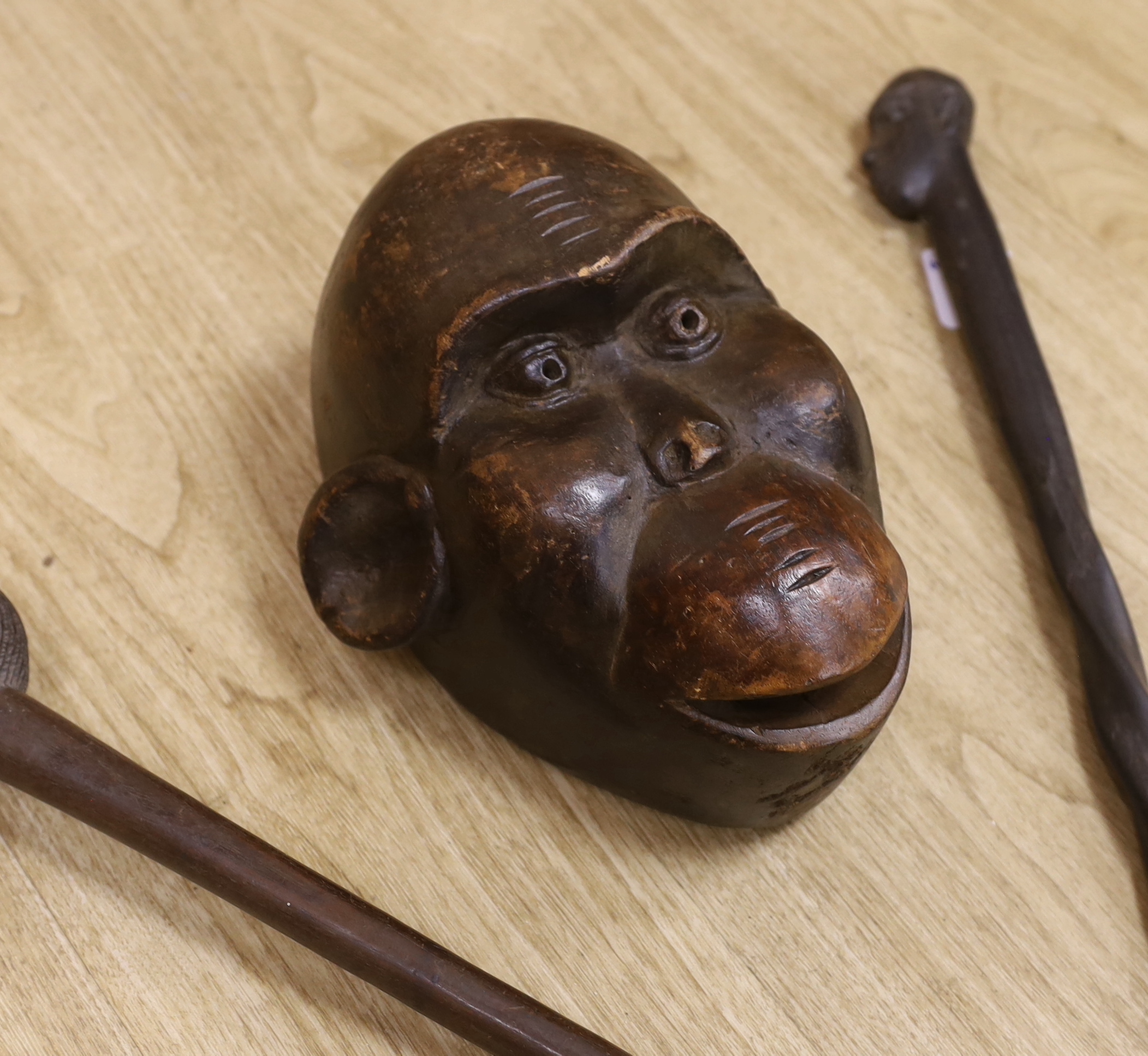 A tribal mask, a Knobkerrie and stick with carved head, stick 62.5cm